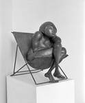 880003 Afbeelding van een beeldhouwwerk voorstellende een vrouw zittend in een klapstoel, vermoedelijk op een ...